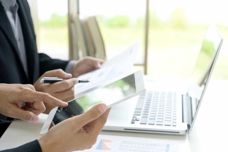 Attorneys going over files on a tablet and laptop
