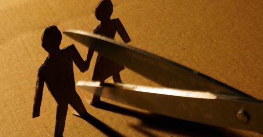 Scissors cutting a paper husband and wife