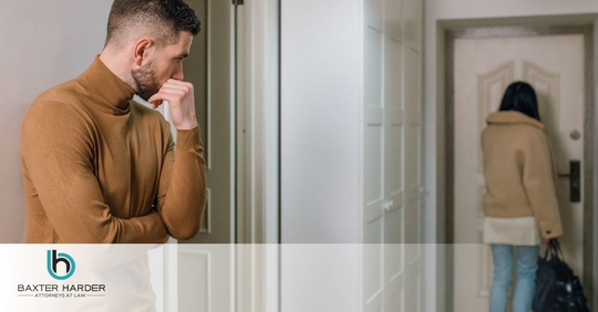 woman leaving home while man watches her go