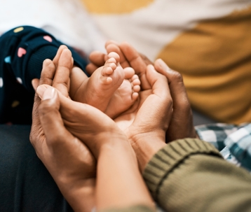 Mom and dad holding baby's feet